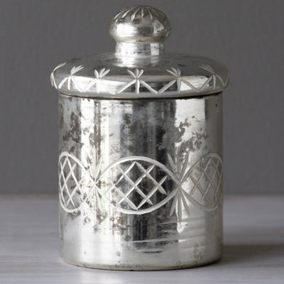 This Mercury Glass Etched Jar with Lid is modeled after vintage canisters.  This lustrous canister has an etched scroll pattern and antiqued finish. Add this jar to your vanity for luxurious storage for your makeup supplies!  Item Dimensions: 3.75"L x 3.75"W x 5.75"H