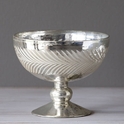 Modeled after vintage compote bowls, this lustrous mercury glass compote has an etched wreath feature and antiqued finish. Just as beautiful on its own while waiting to hold your favorite blossoms.  Item Dimensions: 6"L x 6"W x 4.75"H