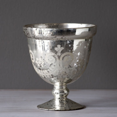 Modeled after vintage compote bowls, this lustrous mercury glass compote has an etched scroll feature and antiqued finish. Just as beautiful on its own while waiting to hold your favorite blossoms.  Item Dimensions: 5.75"L x 5.75"W x 6.5"H