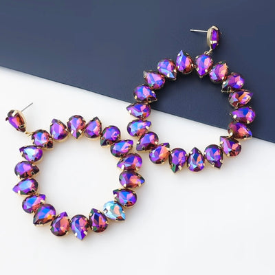 Every jewelry box needs a pair of these Purple Iridescent Rhinestone Loop Earrings. Make a bold statement with these gorgeous earrings, whether pairing them with a cocktail dress or simple jeans!