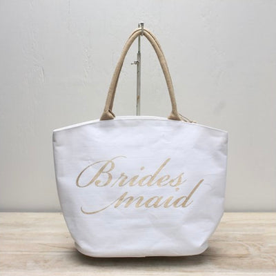 Looking for bridesmaid gifts? Grab one of these White & Gold Bridesmaid Totes for each of your bridesmaids! Fill it with some of their favorite things or wedding day essentials. Helps the bridesmaid stay organized from wedding day and beyond. Tote is made of cotton and jute fabric with white and gold finish.   Travel tote measures approximately 19 x 14 x 7.5 inches.