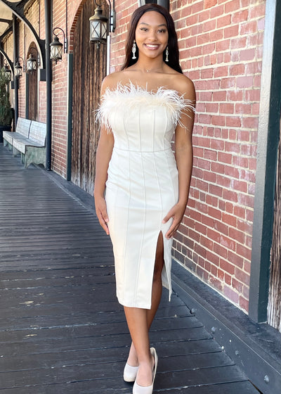 Stop the show in this Cream Feather Pleather Midi Dress! This midi dress features a feather neckline and a flirty front skirt slit.  The detachable feathers makes this dress so versatile! The soft pleather has a slight stretch to give you that poured in look! Perfect rehearsal dinner dress!