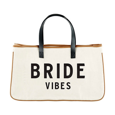 The Bride Vibes Bag is the way to go when wanting to escape in style! The genuine leather handles are stitched to a heavyweight canvas that provides a clean modern look! This tote is offered in a simplistic design that you can carry anywhere; the perfect getaway bag!
