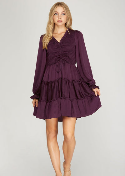 Pop out this fall in this beautiful plum mini dress! This long sleeve dress has a smocked bodice with a tiered skirt. Pair with a cute pair of booties for a girls day out or dress it up with a pair of cute heels for a date night!