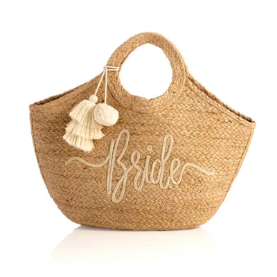 The Jute “Bride” Tote gives a summery update to all your bridal essentials! This beautiful woven tote features “Bride” stitched in a whimsical font.  Tassels hang from the double handles. Perfect for Honeymoon getaways!  Measures L 20" x W 8" x H 9", and made from natural jute.