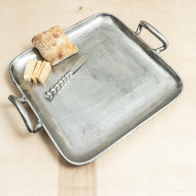 Our Antiqued Square Handle Tray is perfect for transporting everything from tea and scones to cocktails and hors d’oeuvres. Distressed for an old world look, the variations in hand craftsmanship make each piece unique!  Measures 14.1” X 15.1”
