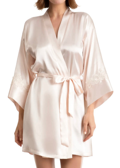 The Satin Robe in Blush Champagne by In Bloom features embroidered lace inset into the  long sleeves, a belted waist, and detailed with a shawl collar. 