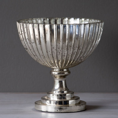 Modeled after vintage compote bowls, this lustrous mercury glass compote has a ridged feature and antiqued finish. Just as beautiful on its own while waiting to hold your favorite blossoms.  Item Dimensions: 7"L x 7"W x 7.5"H