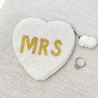 The Heart Shaped Beaded “MRS” Zip Pouch is the perfect accessory to go along with our bride or Mrs. totes!  Such a sweet gift for a bride to be! With intricate beading, and pom pom detail, this pouch is both practical and adorable! 