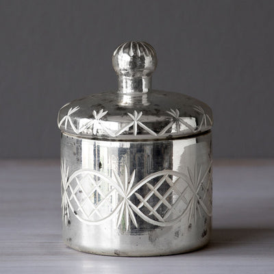 Modeled after vintage canisters, this lustrous mercury glass lidded cylinder has an etched scroll pattern feature and antiqued finish. Add this piece to your vanity for everything from makeup supplies to your special rings!  Item Dimensions: 3"L x 3"W x 4.5"H